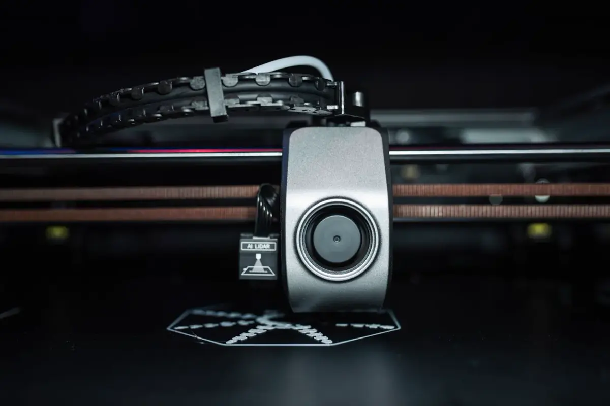 Tête d’impression d’une imprimante 3D au-dessus de son plateau, vue de face